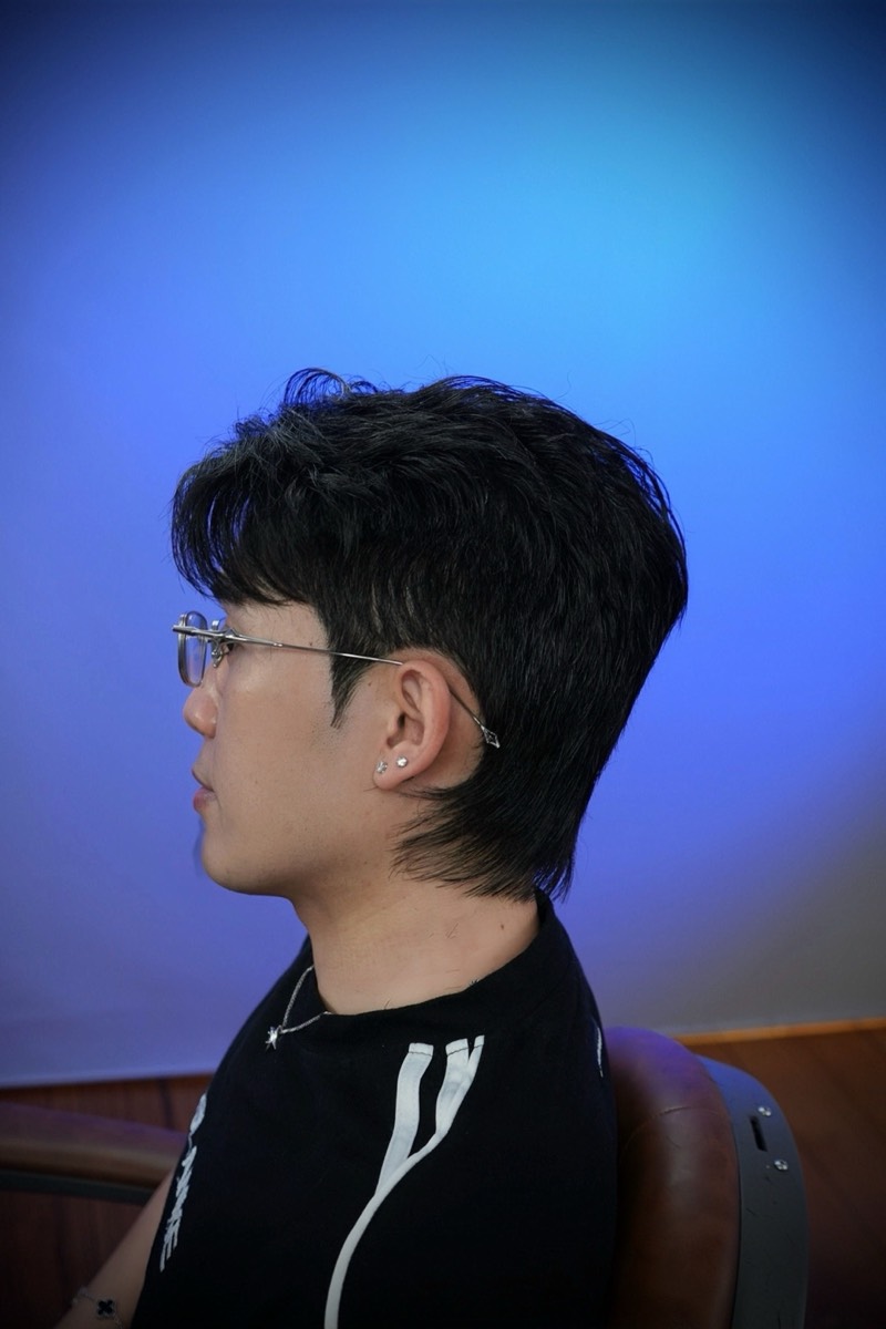 Textured mullet with a soft taper on a blue backdrop