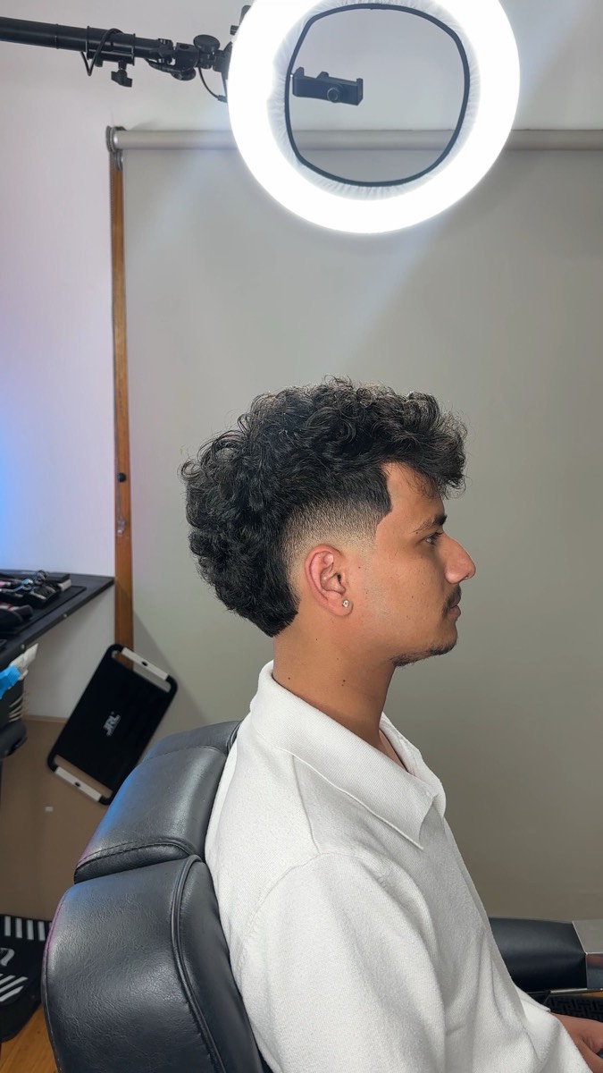 Curly top with a clean low skin fade