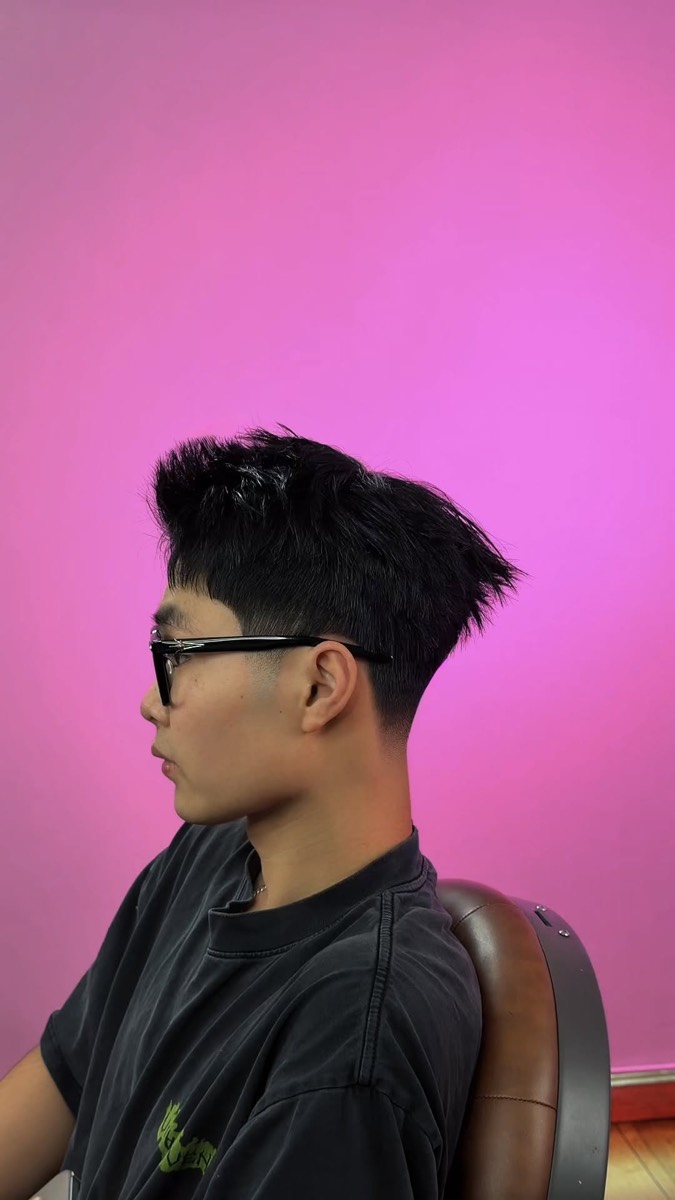 High fade with a spiky textured top and glasses
